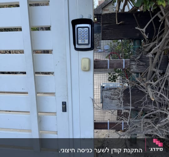 מערכת אינטרקום מותקנת על שער לבן